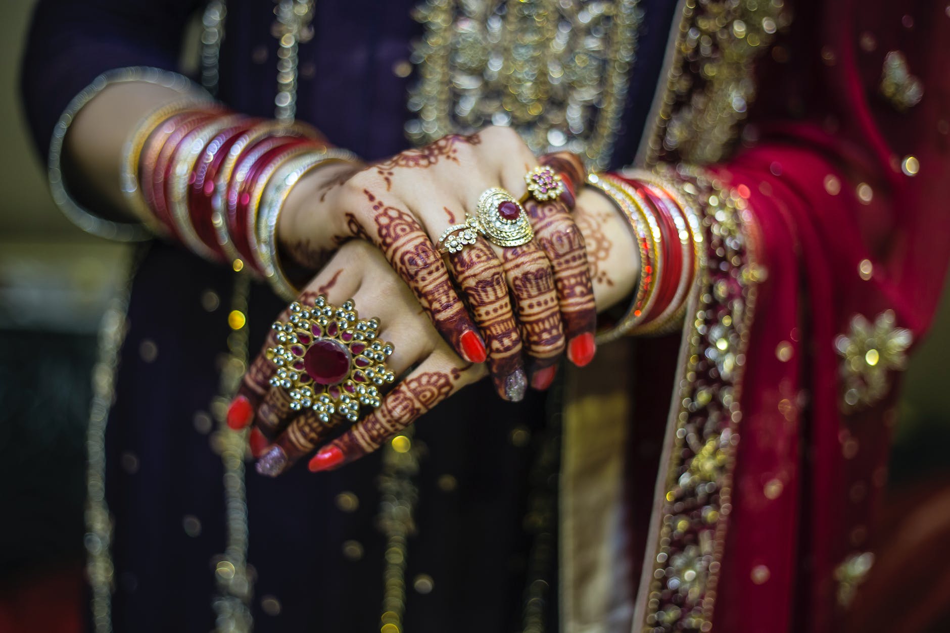 woman wearing red and gold dress holding up hands